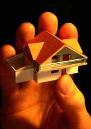 Hand holding miniature house