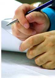 hands and pen signing a document